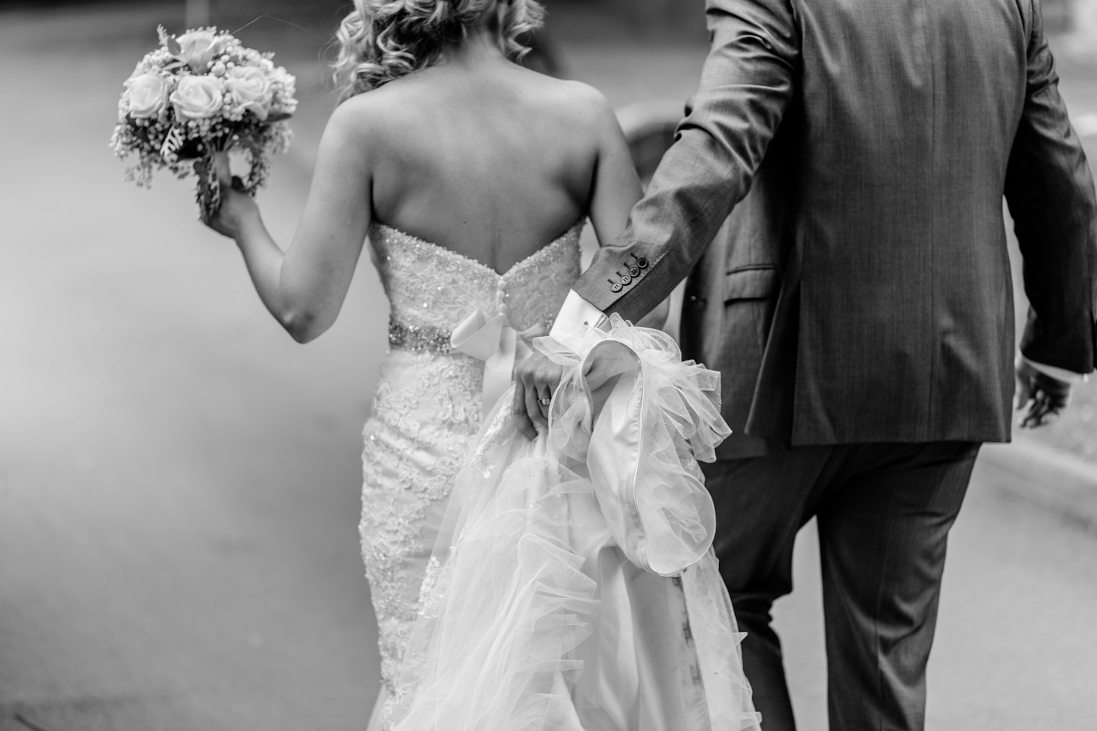 Novios de espalda en blanco y negro, ella con el ramo en la mano
