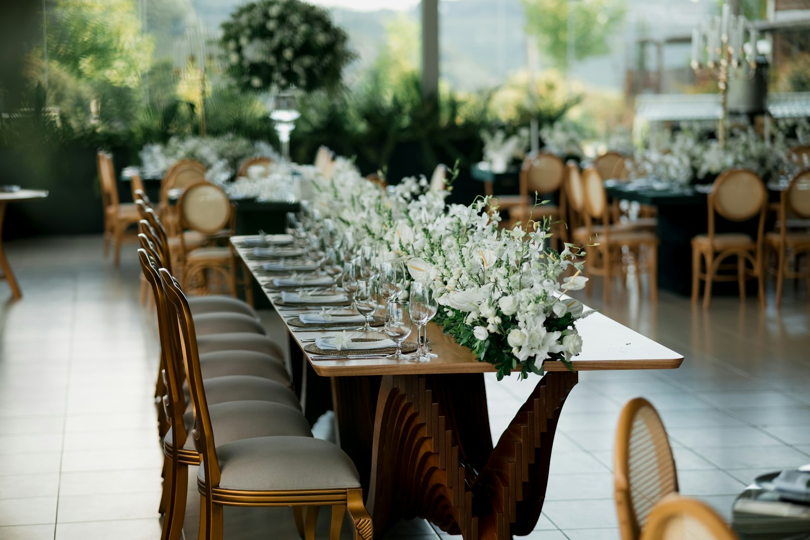 Mesa larga en un jardín con flores blancas